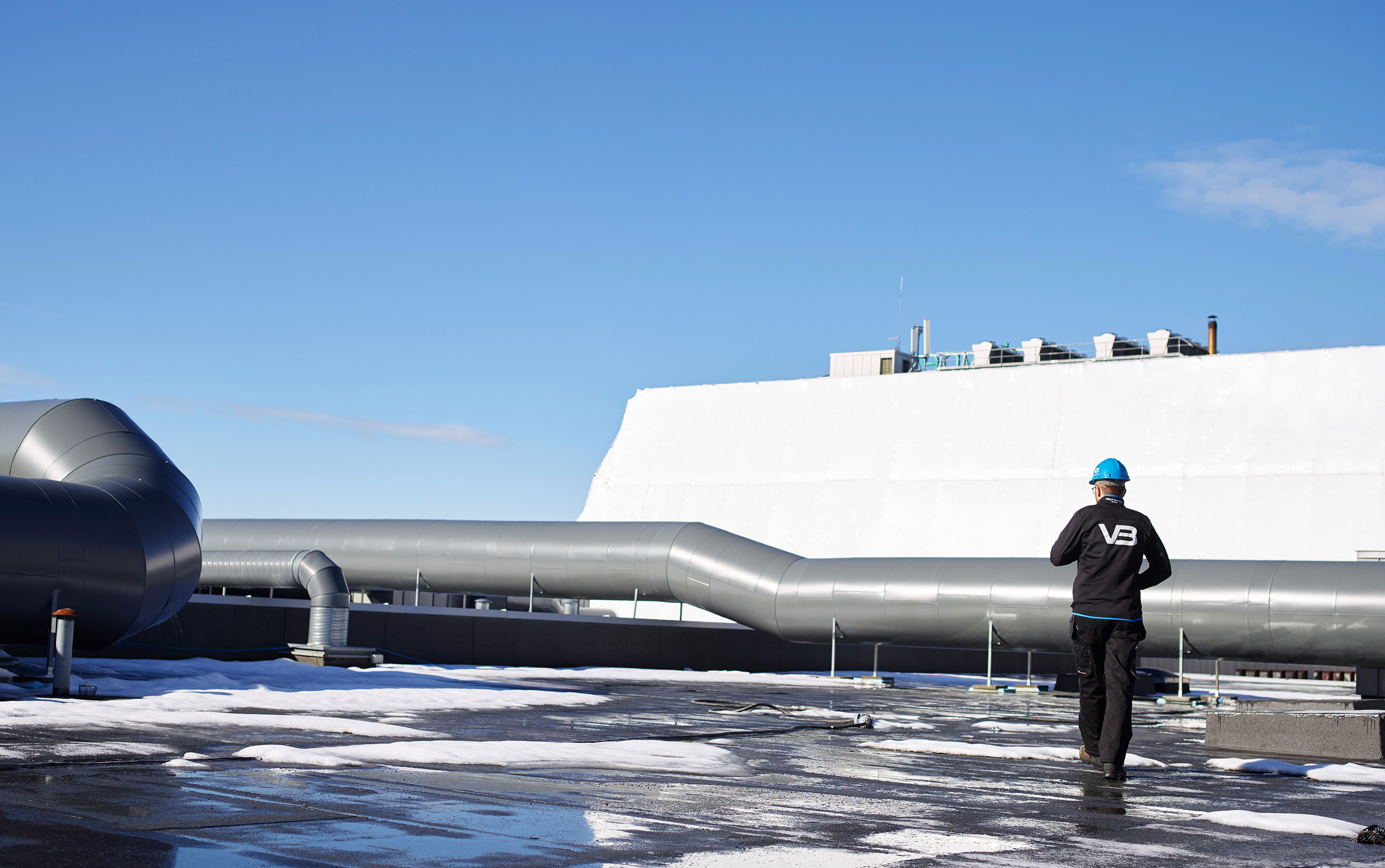 VB Rørlegger på arbeid på taket på et næringsbygg med ventilasjonsanlegg