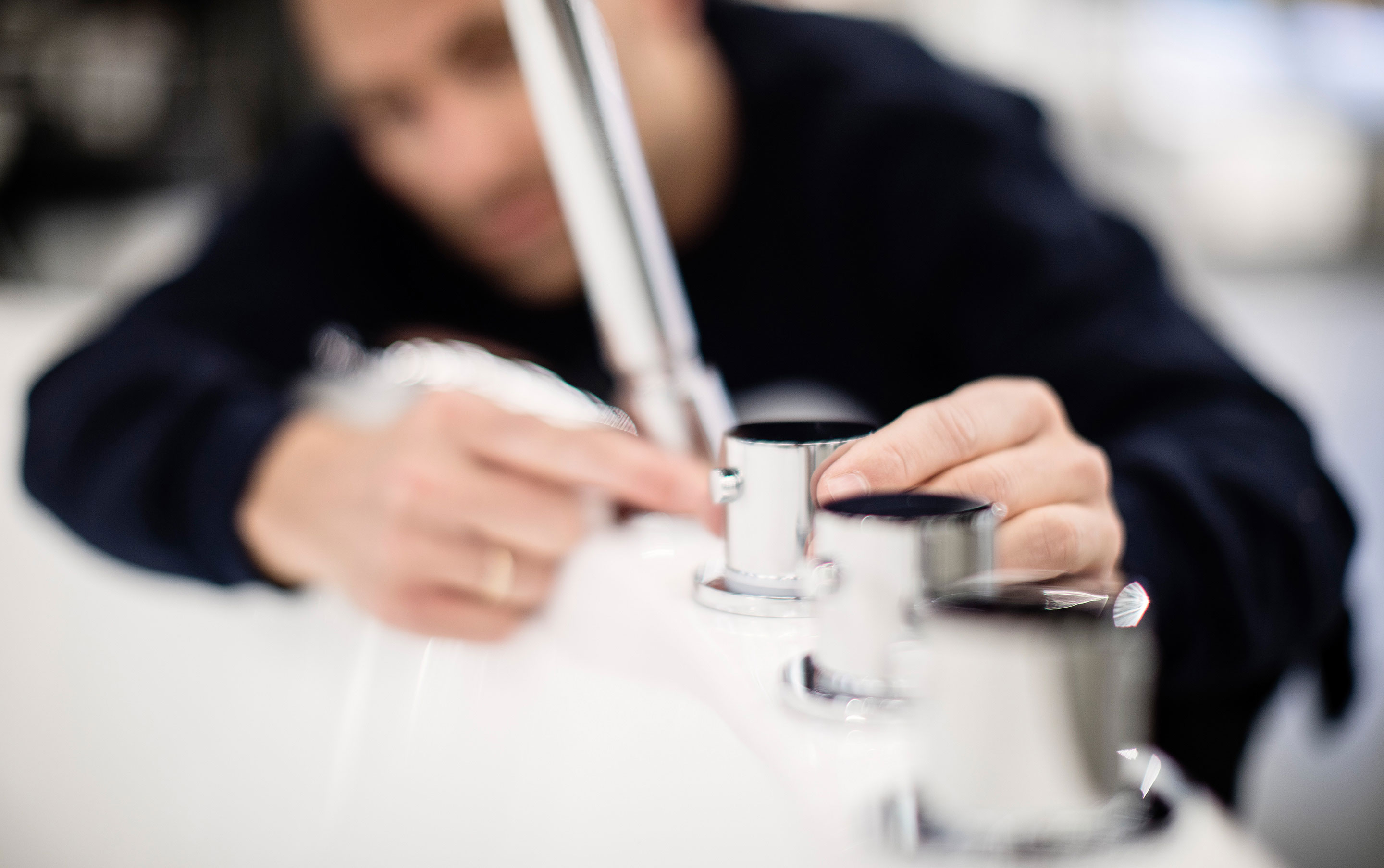 VB-rørlegger monterer badekarbatteri. Uskarpt bilde.